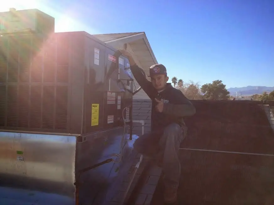 HVAC technician performing Boiler Repair on a rooftop unit in Hartselle
